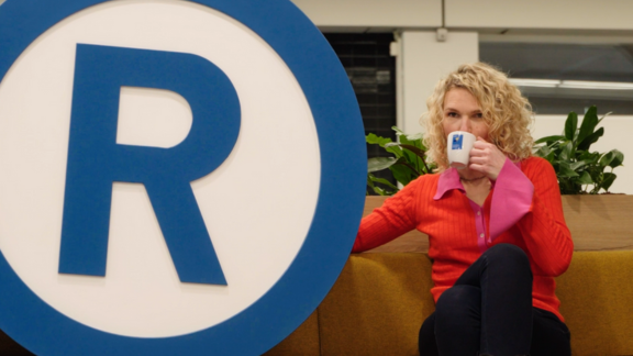 Vrouw naast een levensgroot R-teken 